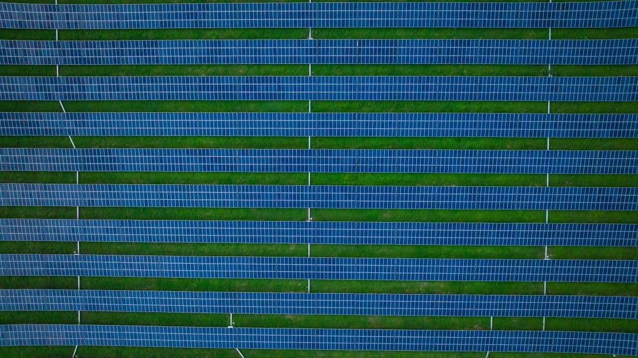 Aerial view of solar panel rows across a ground-mount solar farm